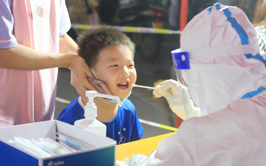 Nhân viên y tế lấy mẫu xét nghiệm COVID-19 tại một điểm xét nghiệm ở TP Trịnh Châu, tỉnh Hà Nam ngày 8-1. Ảnh: REUTERS