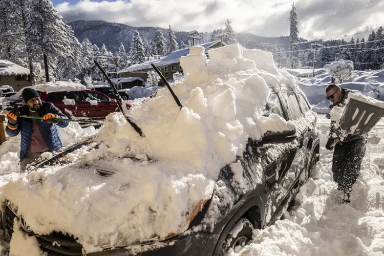 Người dân California, Mỹ đang xúc tuyết khỏi một chiếc xe hơi. Ảnh: AP