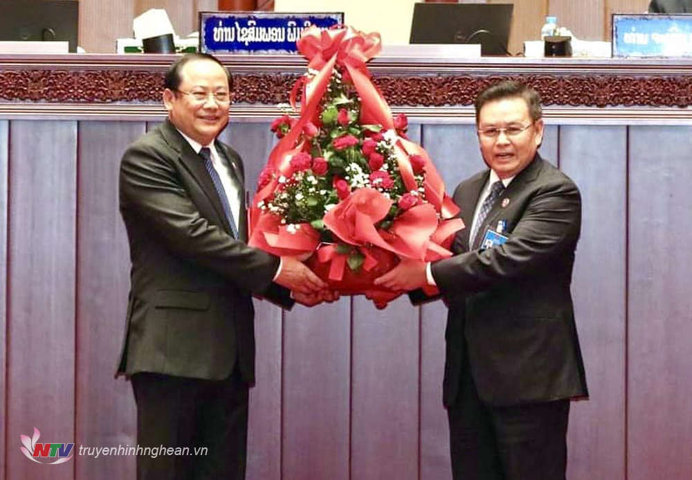 Chủ tịch Quốc hội Lào Xaysomphone Phomvihane (phải) tặng hoa chúc mừng tân Thủ tướng Sonexay Siphandone