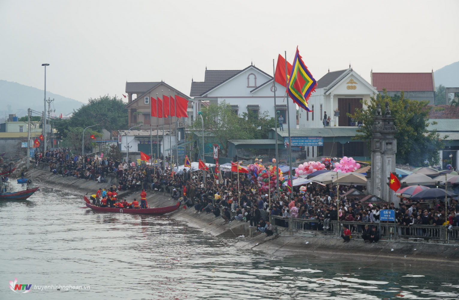 Cổ động viên tham gia cổ vũ nhiệt tình tại lễ hội đua thuyền truyền thống phường Quỳnh Phương, Thị xã Hoàng Mai