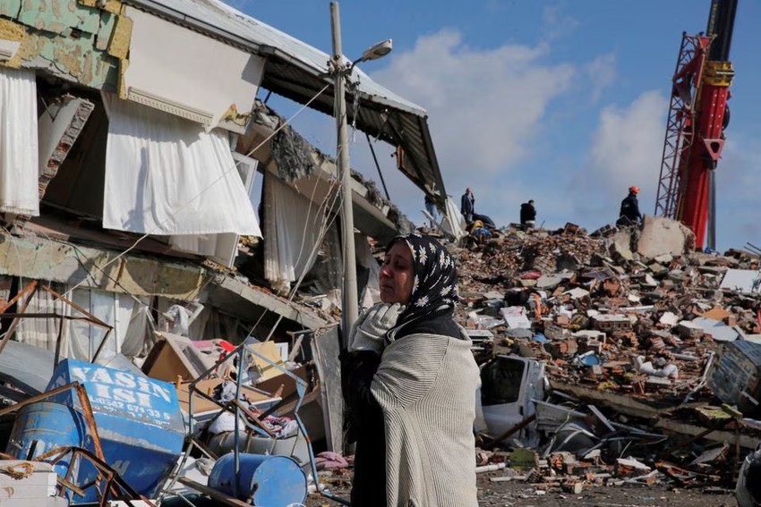 Một người phụ nữ đứng trước tòa nhà đổ nát sau trận động đất ở TP Gaziantep (Thổ Nhĩ Kỳ) ngày 7-2. Ảnh: REUTERS