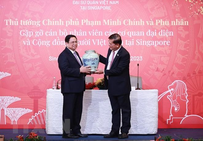 Thủ tướng Phạm Minh Chính tặng quà cho đại diện cán bộ, nhân viên các cơ quan đại diện Việt Nam tại Singapore. 
