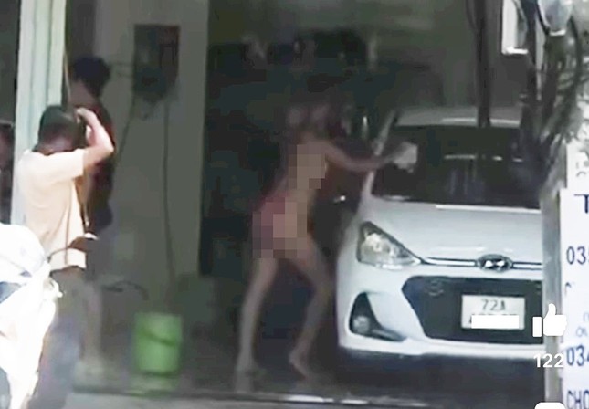Hình ảnh cô gái mặc bikini tạo dáng rửa xe để chụp hình. Ảnh cắt từ clip.