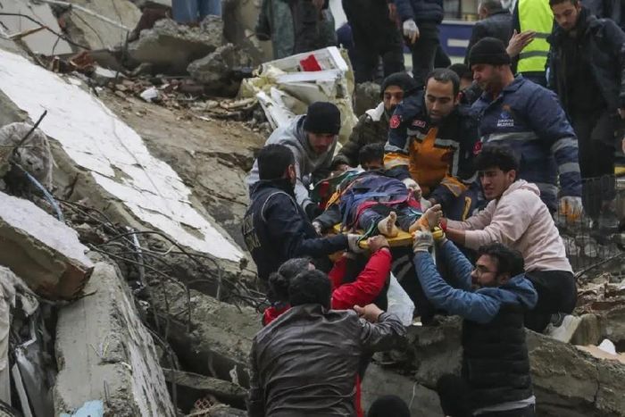 Người dân và đội cứu hộ giải cứu người bị kẹt trong một tòa nhà bị sập do thảm họa động đất ở Thổ Nhĩ Kỳ ngày 6/2. (Nguồn: AP)