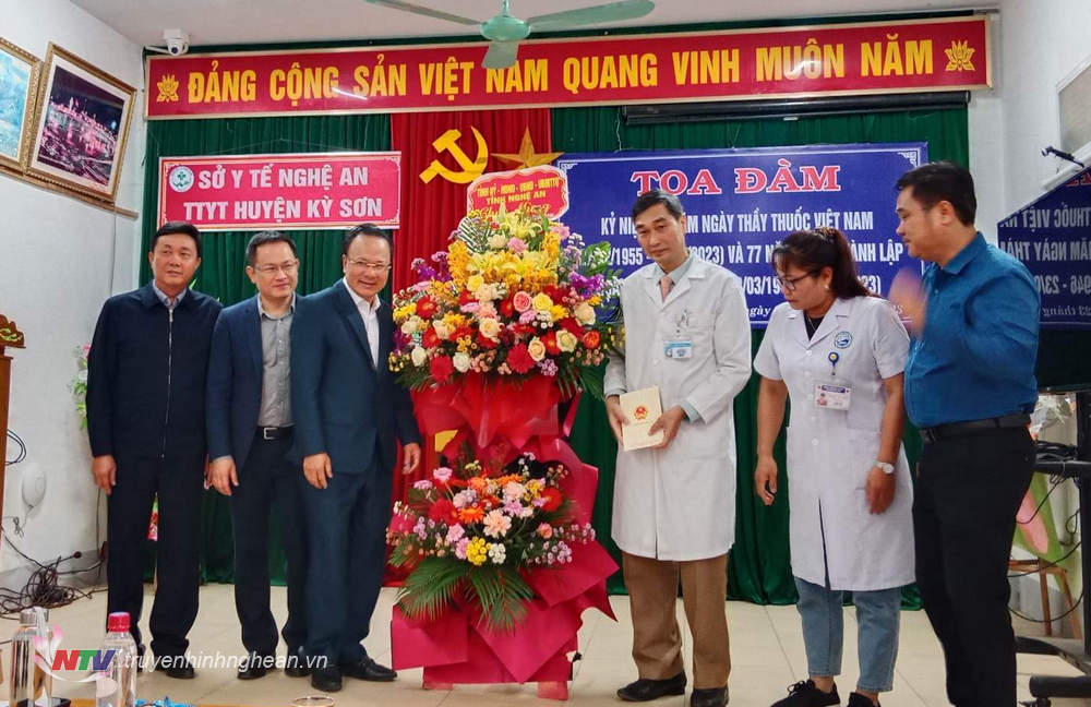 Phó Chủ tịch Thường trực HĐND tỉnh Nguyễn Nam Đình cùng đoàn công tác tặng hoa chúc mừng cán bộ, y bác sĩ Trung tâm Y tế huyện.