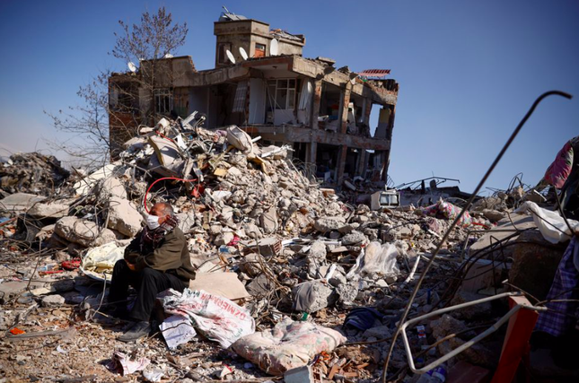 Một người đàn ông ngồi trên đống đổ nát sau động đất ở Kahramanmaras, Thổ Nhĩ Kỳ, ngày 11/2. (Ảnh: Reuters)