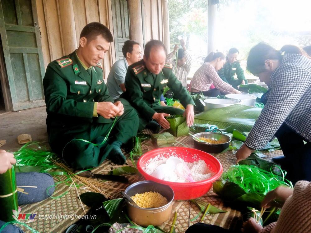 Thiếu tá Bùi Đức Công (thứ nhất bên trái), quân y Đồn Biên phòng cửa khẩu quốc tế Nậm Cắn gói bánh tặng các hộ nghèo dịp Tết Giáp Thìn 2024.