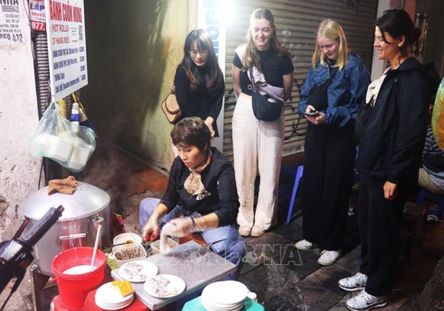 Du khách xem làm bánh cuốn nóng trên phố Hàng Điếu. Ảnh: Vũ Thanh/TTXVN phát