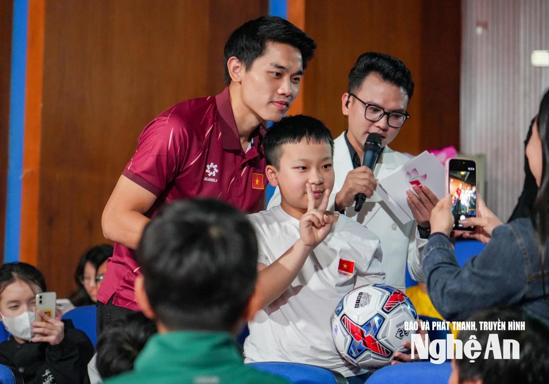 Tiền đạo Nguyễn Đình Bắc tặng quà và chụp ảnh lưu niệm với khán giả tại Chương trình giao lưu được tổ chức tại Báo và Phát thanh, truyền hình Nghệ An. Ảnh: Minh Quân