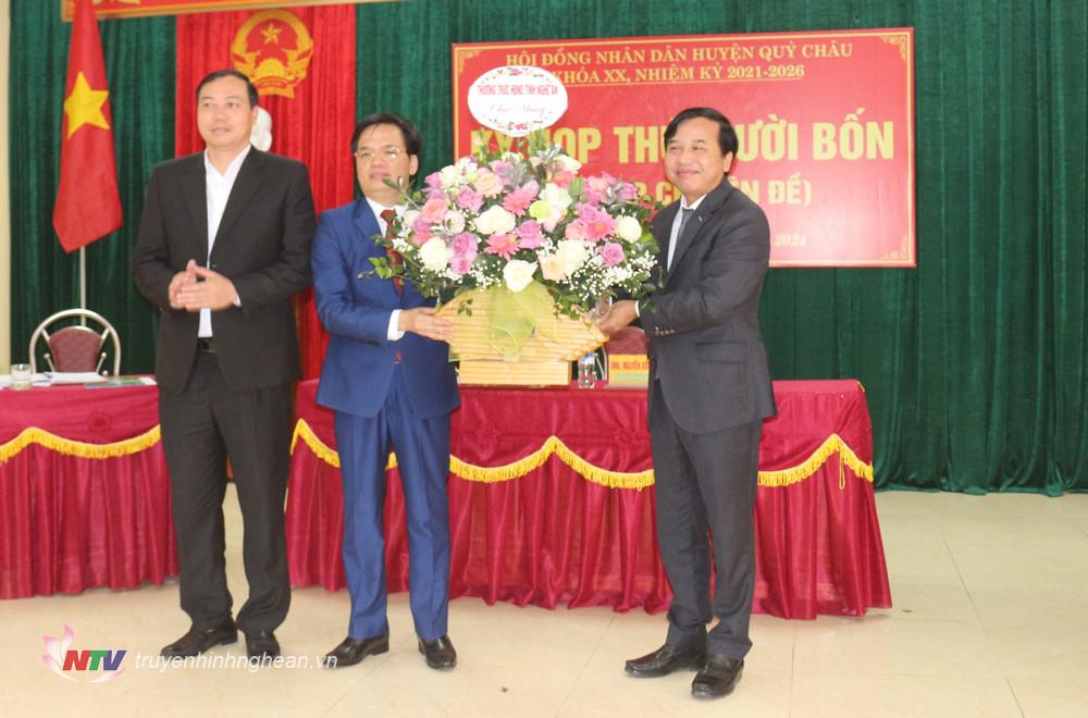 Đồng chí Nguyễn Như Khôi - Phó Chủ tịch HĐND tỉnh tặng hoa chúc mừng tân Chủ tịch UBND huyện Quỳ Châu.