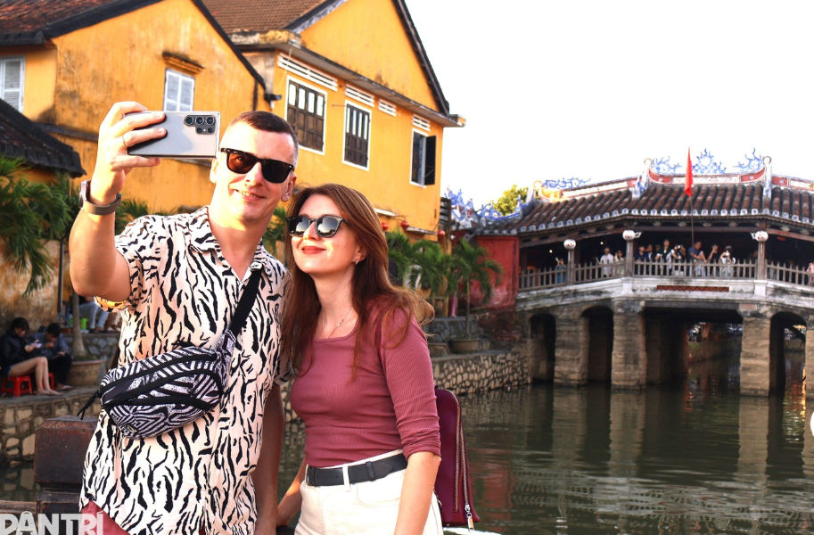 Khách nước ngoài chụp ảnh lưu niệm tại chùa Cầu (Ảnh: Ngô Linh).