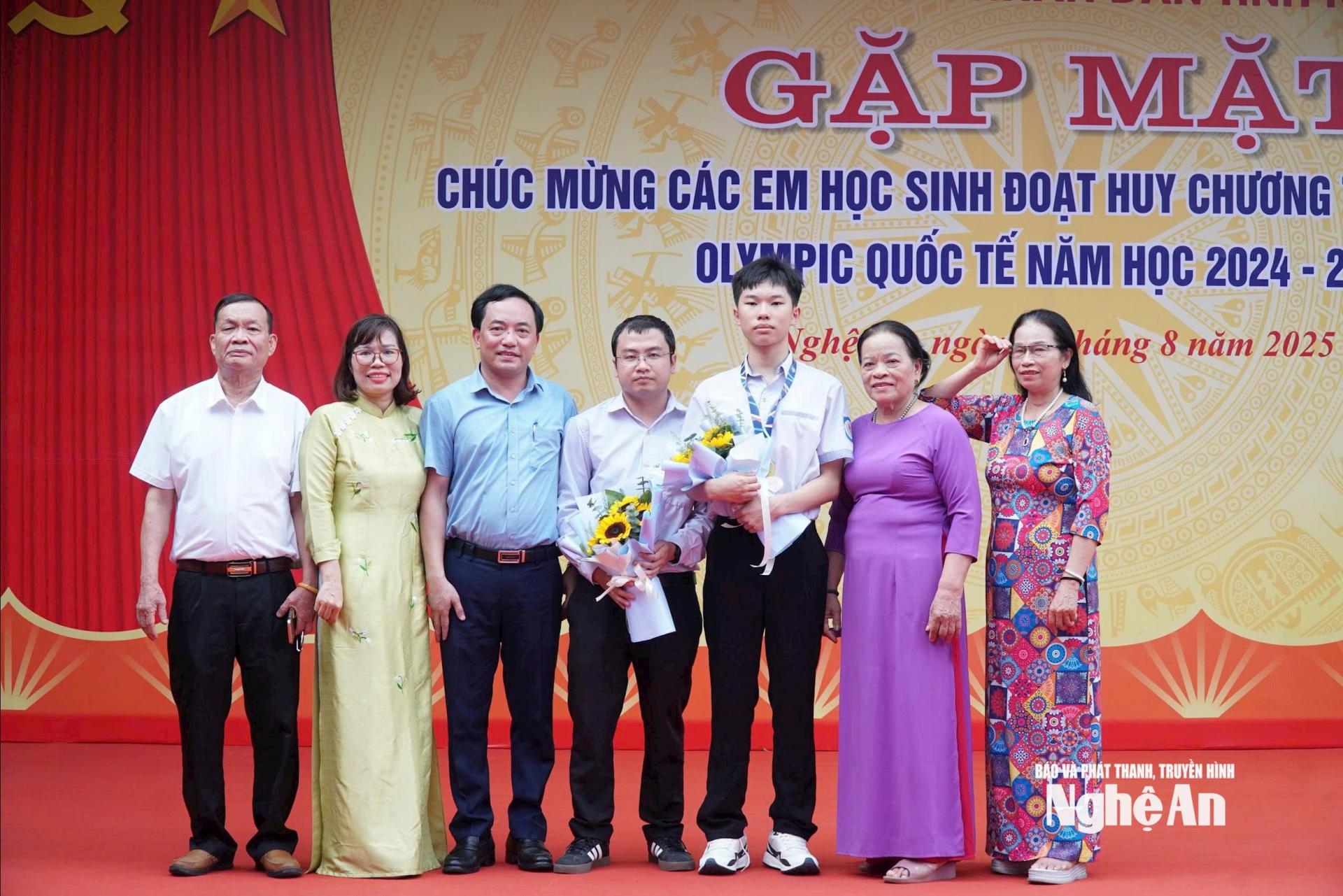 Em Nguyễn Thế Quân chụp ảnh cùng gia dình và thầy giáo chủ nhiệm tại buổi gặp mặt tuyên dương học sinh đạt giải cao ở các kỳ Olympic do Trường THPT chuyên Phan Bội Châu tổ chức. Ảnh: M.H