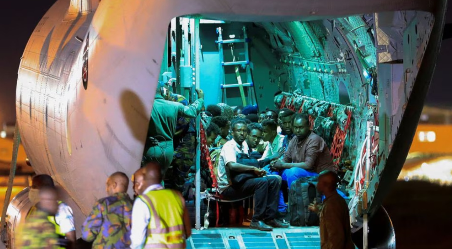 Những người sơ tán khỏi Sudan ngồi bên trong máy bay quân sự. (Ảnh: Reuters)