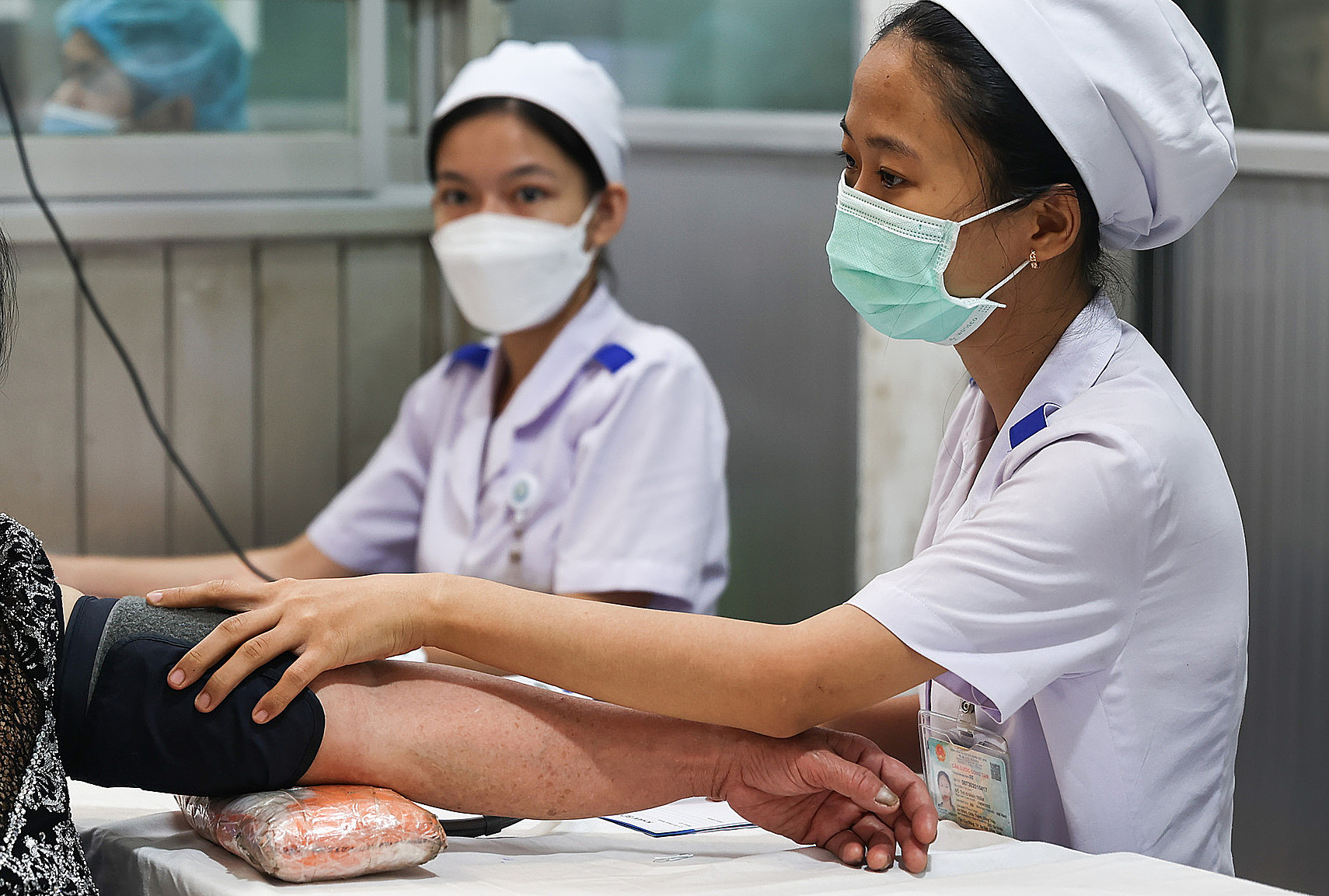 Nhân viên y tế đo huyết áp cho bệnh nhân. 