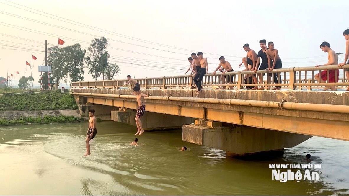 Trẻ em nhảy cầu tắm ở kênh đào Ba ra Đô Lương đoạn qua xã Quan Thành. Ảnh: Văn Trường