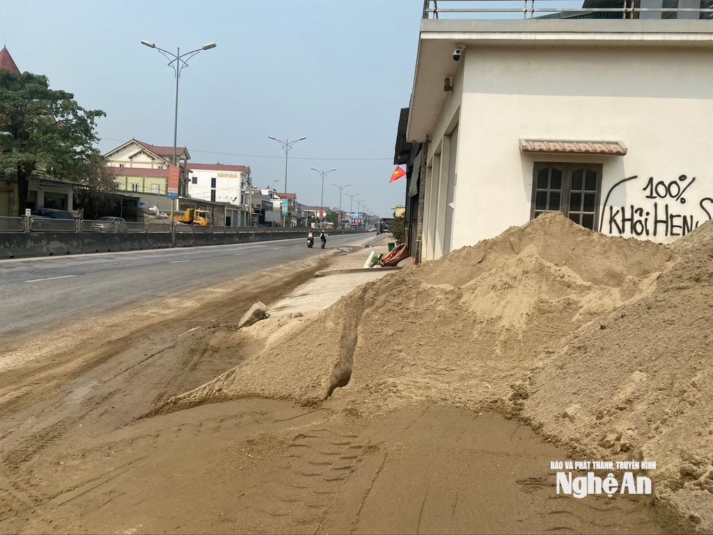 Một số bãi tập kết cát, xe vận chuyển ra, vào liên tục khiến nước và bùn chảy tràn lên mặt đường, gây trơn trượt. Ảnh: Văn Trường