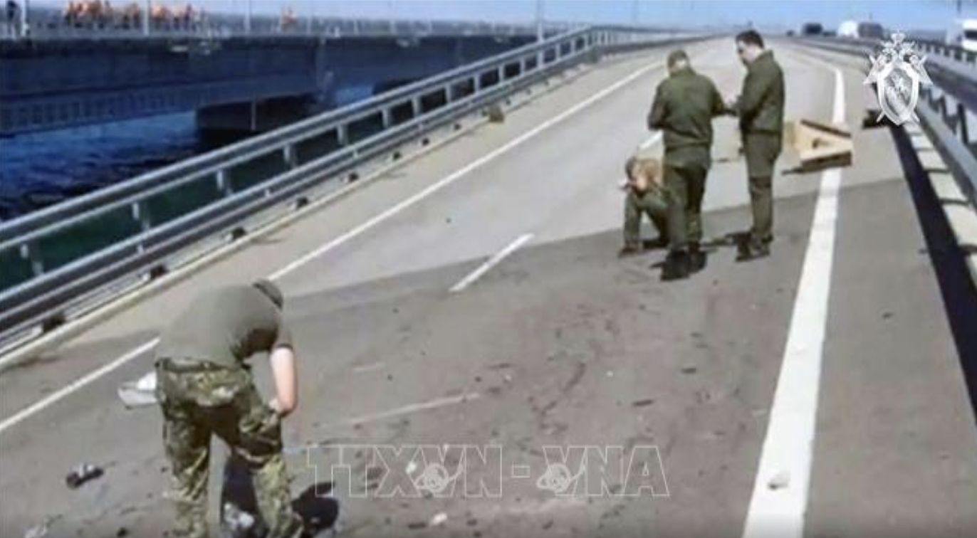 Ngày 17/7/2023, hoạt động vận tải đường sắt trên Cầu Crimea đã được nối lại khi chuyến tàu đầu tiên khởi hành qua cầu hướng tới vùng Krasnodar. Trong khi đó, Cơ quan Điều tra Liên bang Nga cho hay cơ quan mật vụ Ukraine đã thực hiện một cuộc tấn công Cầu Crimea rạng sáng 17/7, khiến một nhịp cầu bị hư hại và hai dân thường thiệt mạng. Hiện cơ quan này đang tiến hành điều tra vụ việc. Giao thông trên Cầu Crimea bị tạm dừng do tình trạng khẩn cấp. Trong ảnh là nhân viên Cơ quan Điều tra Liên bang Nga điều tra tại hiện trường vụ tấn công Cầu Crimea ngày 17/7/2023. Nguồn: AFP/TTXVN