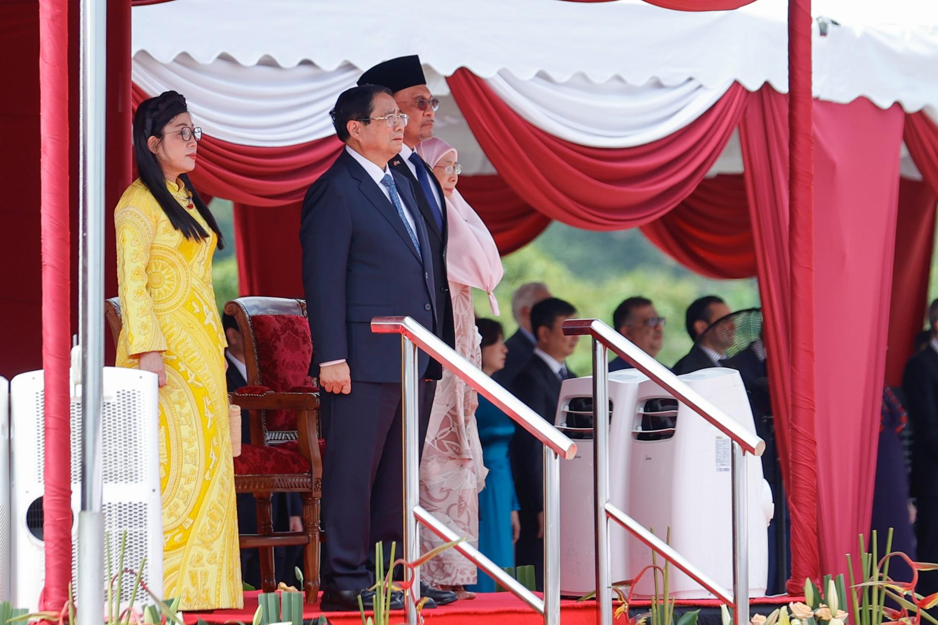 Thủ tướng Anwar Ibrahim và Phu nhân bắt tay chào mừng Thủ tướng Chính phủ và Phu nhân, sau đó cùng nhau di chuyển lên bục danh dự.