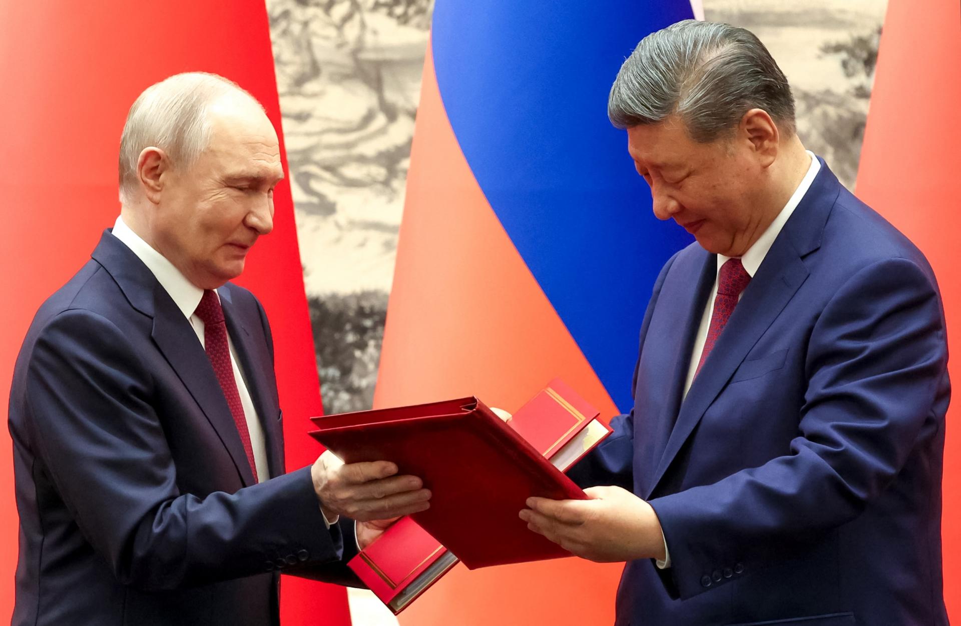 Tổng thống Nga Vladimir Putin và Chủ tịch Trung Quốc Tập Cận Bình trao đổi văn kiện hợp tác sau cuộc hội đàm tại Bắc Kinh, ngày 20/5/2026. Ảnh: AFP