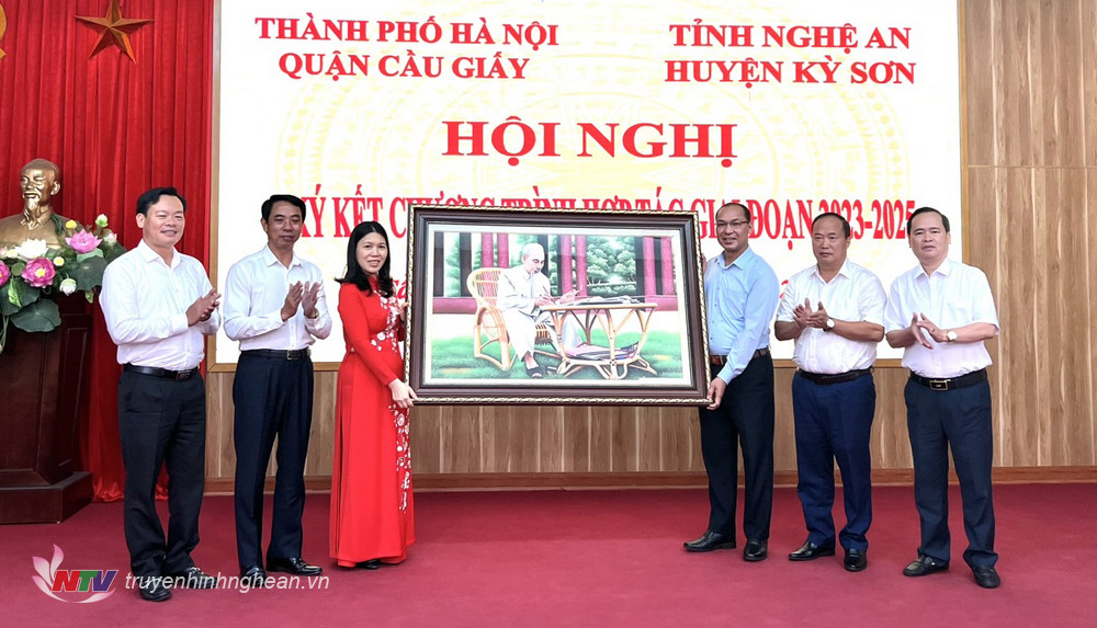 Lãnh đạo quận Cầu Giấy và huyện Kỳ Sơn trao quà lưu niệm.