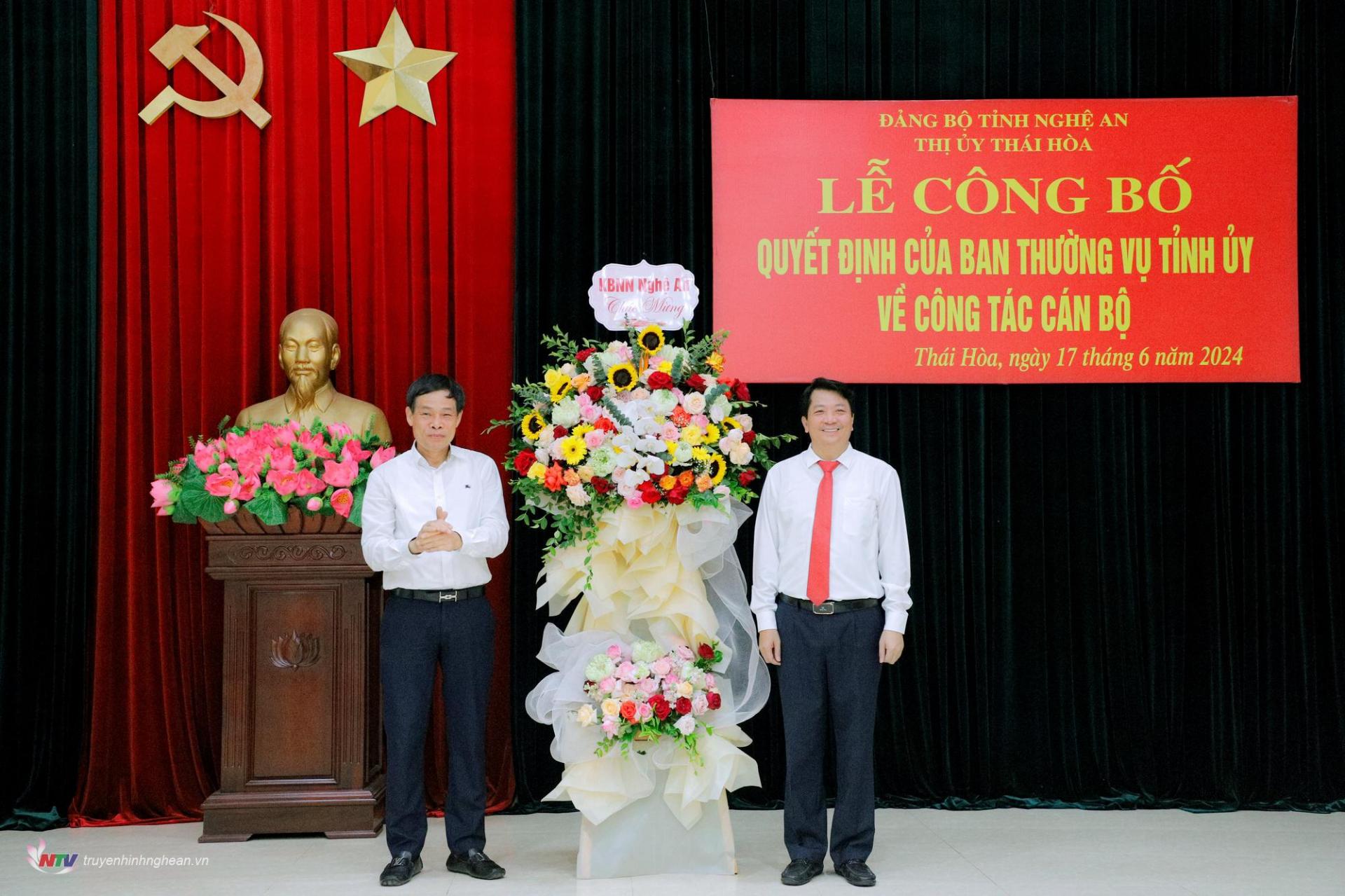Đồng chí Nguyễn Đình Hòa - Giám đốc Kho bạc Nhà nước tỉnh tặng hoa chúc mừng tân Bí thư Thị ủy Thái Hòa
