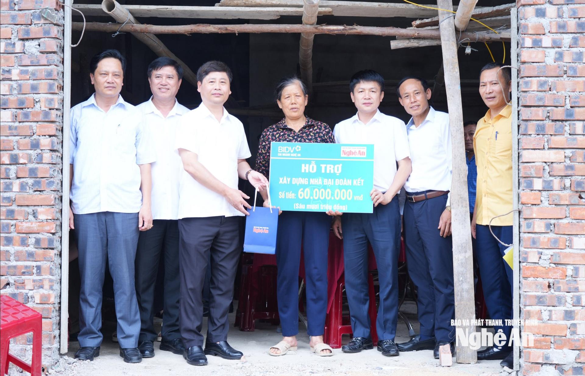 Lãnh đạo 2 đơn vị trao hỗ trợ xây dựng nhà Đại đoàn kết cho hộ bà Lê Thị Khương ở xóm Nam Liên, xã Hải Châu. Ảnh: T.L