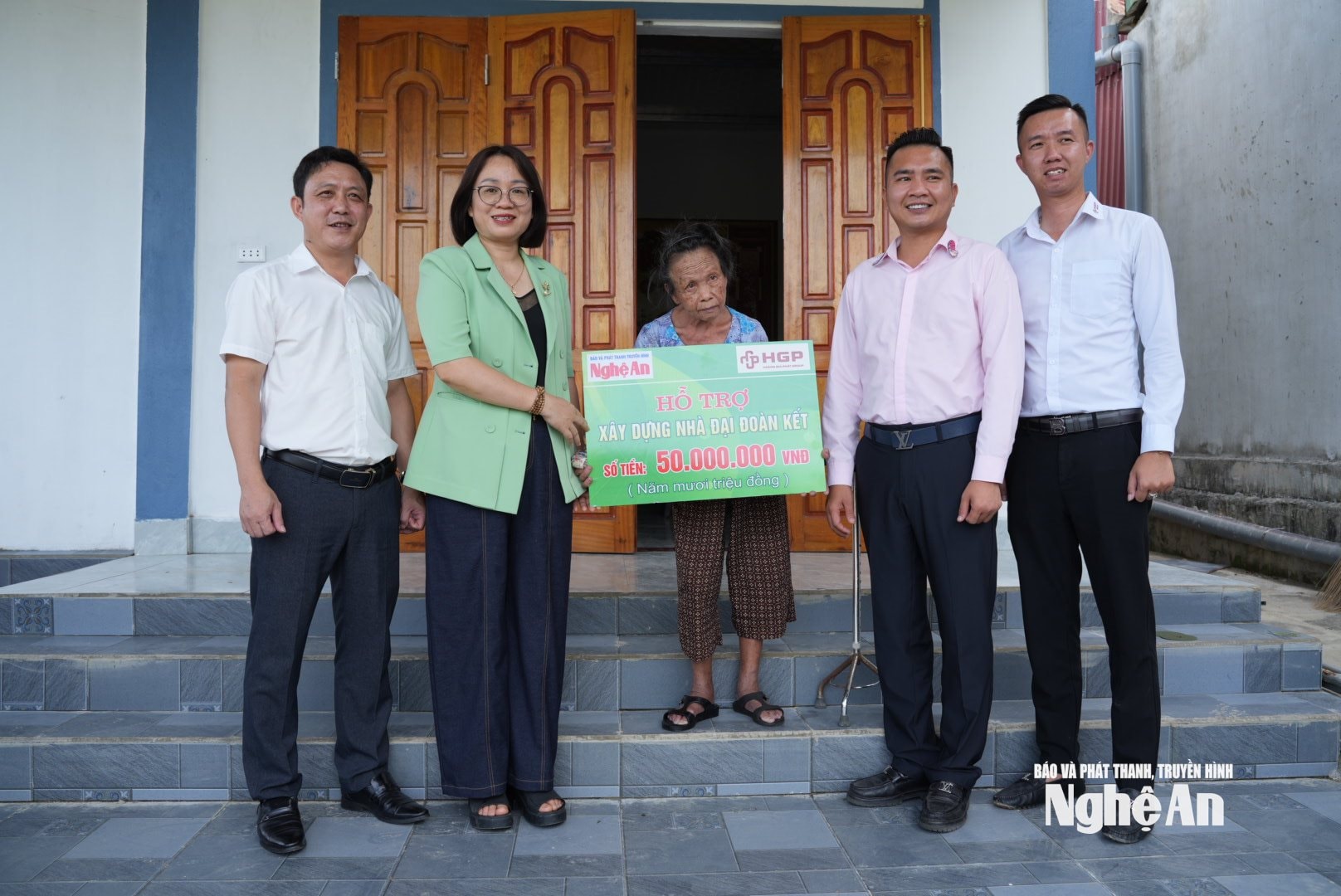 Bà Trần Thị Huyền - Phó Giám đốc Báo và PTTH Nghệ An cùng đại diện lãnh đạo Hoàng Gia Phát Group trao 50 triệu đồng hỗ trợ cho bà Nguyễn Thị Xuân. Ảnh: Nguyễn Toàn