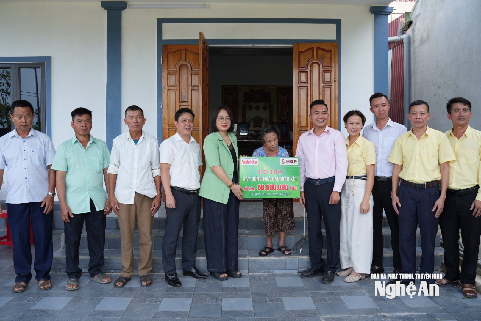 Đại diện đơn vị tài trợ và địa phương tham gia lễ trao 50 triệu đồng hỗ trợ xây nhà Đại đoàn kết cho bà Nguyễn Thị Xuân. Ảnh: Nguyễn Toàn