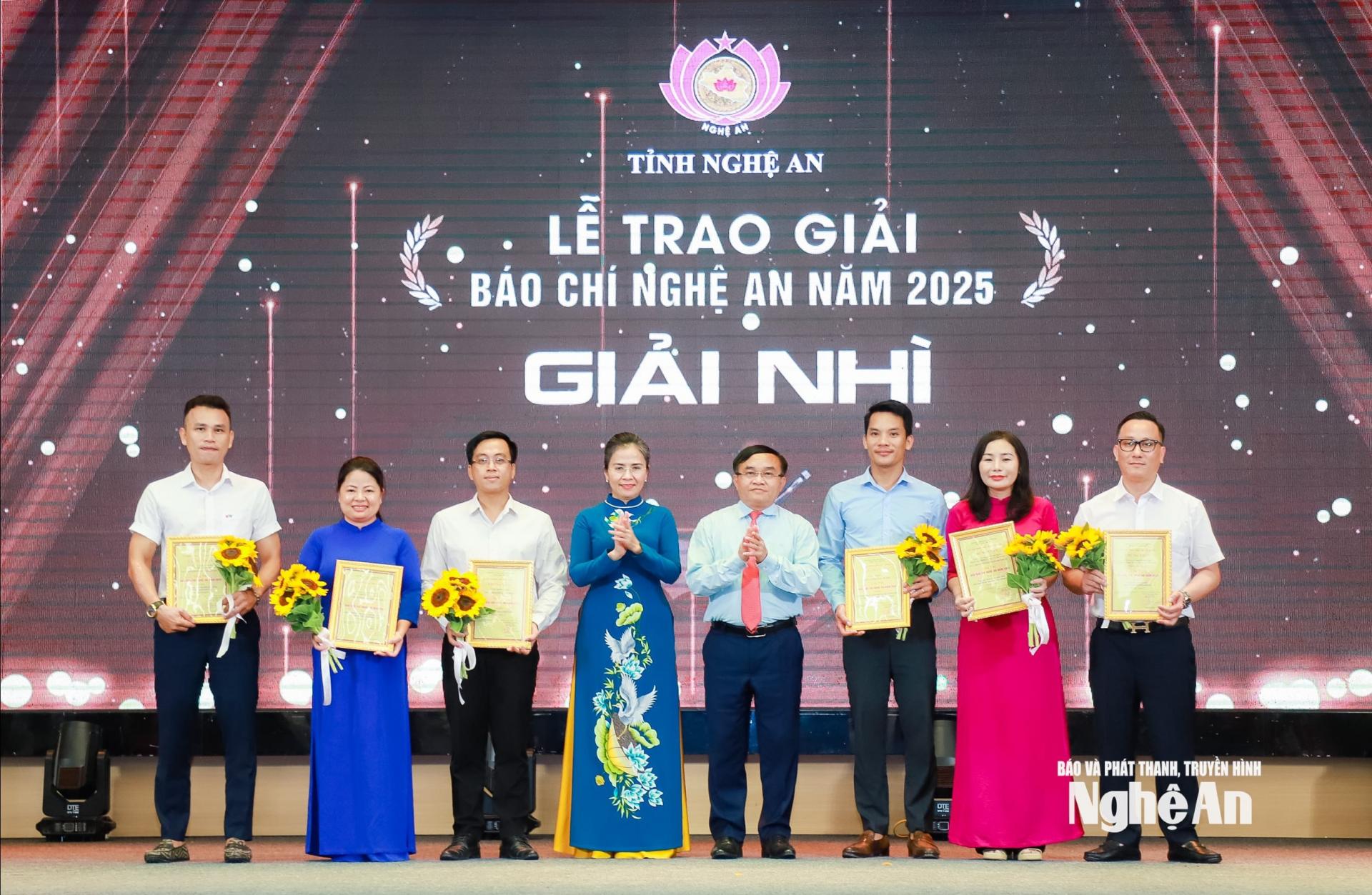 Các đồng chí: Võ Thị Minh Sinh - Phó Bí thư Tỉnh ủy, Chủ tịch Ủy ban MTTQ Việt Nam tỉnh; Ngọc Kim Nam - Ủy viên Ban Thường vụ Tỉnh ủy, Trưởng ban Tuyên giáo và Dân vận Tỉnh ủy trao giải Nhì cho các tác giả, nhóm tác giả đoạt giải. Ảnh: Thành Duy