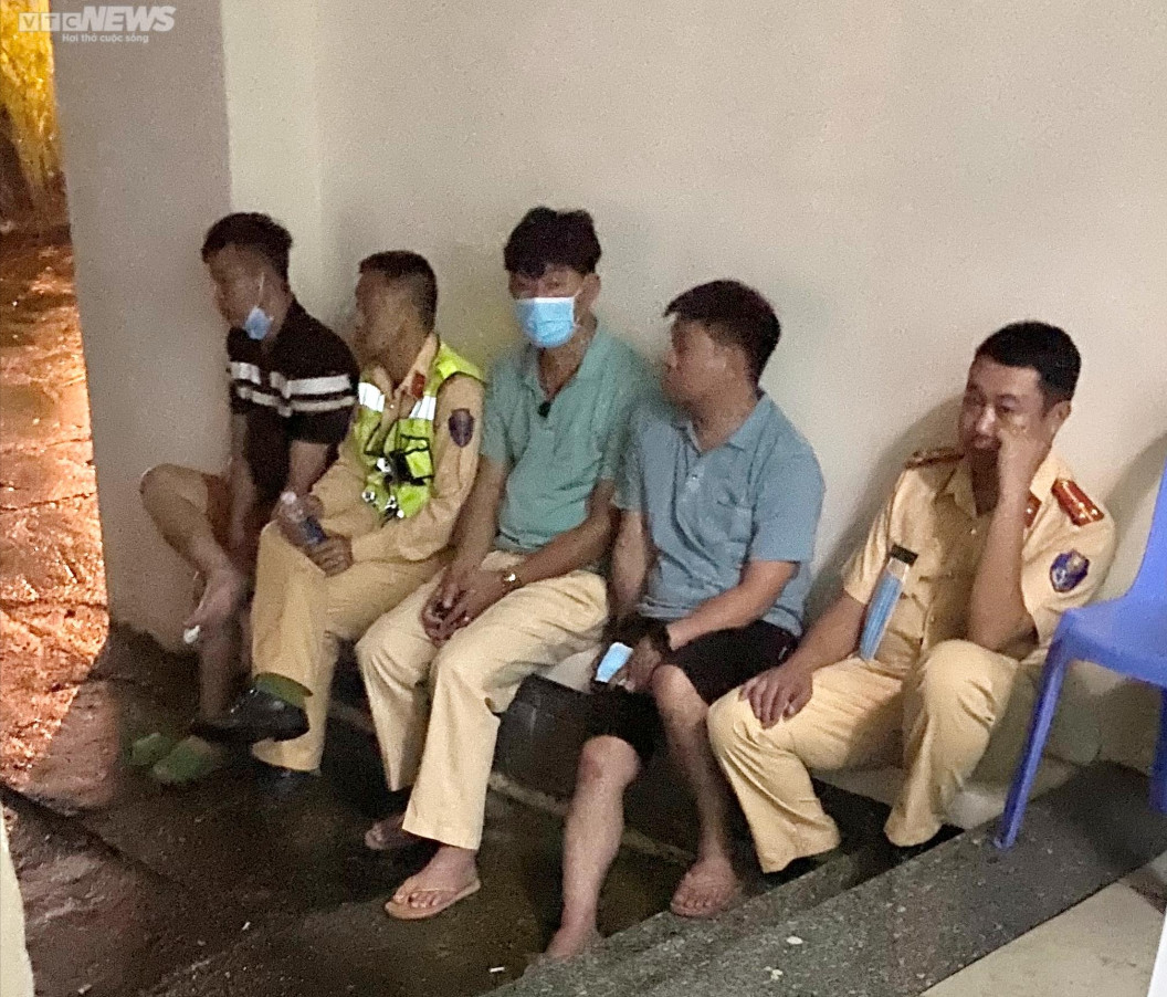 Anh Trung (trái) và anh Hưng (thứ 2 từ phải qua) thất thần ngồi cùng các đồng đội ở khu vực nhà vĩnh biệt Trung tâm Y tế huyện Đạ Huoai.