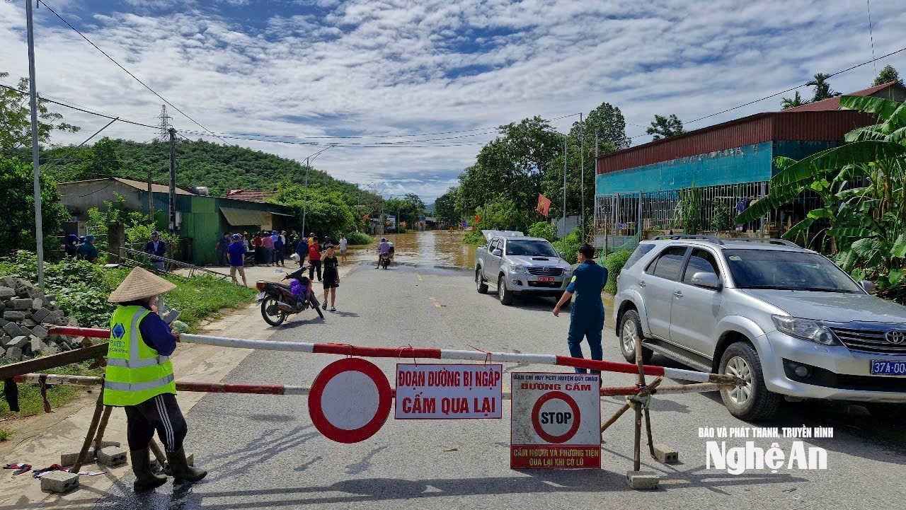 Chính quyền địa phương cùng với đơn vị quản lý đường bộ lập hàng rào chắn hạn chế qua lại trên đoạn đường bị ngập. Ảnh: Nhật Lân