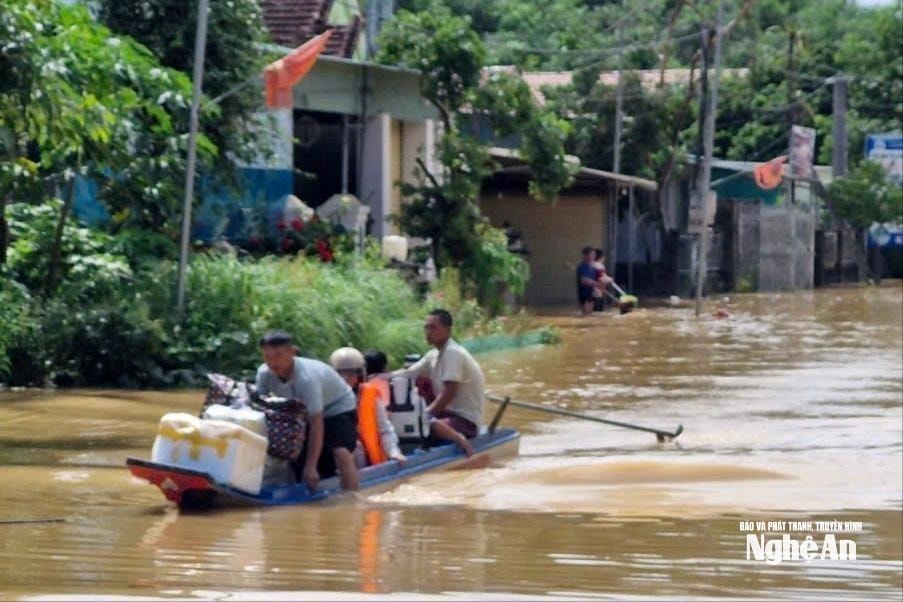 Nước lũ dâng cao nên một số đoạn Quốc lộ 48 bị ngập sâu khiến người dân phải dùng thuyền để di chuyển. Ảnh: Nhật Lân