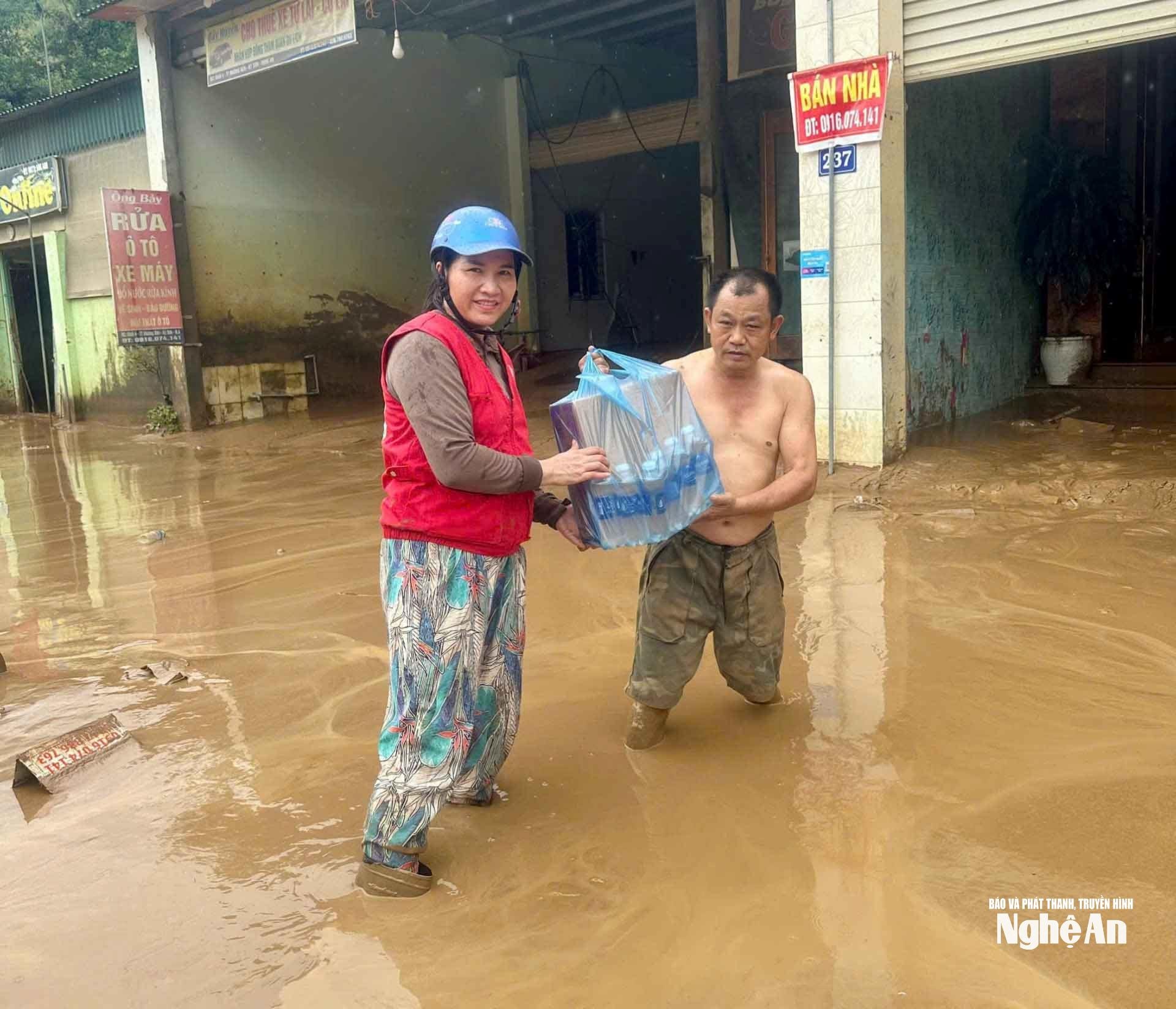 Đại diện Hội Chữ thập đỏ xã Mường Xén trao tặng mì tôm và nước sạch cho người dân. Ảnh: Quang Huy