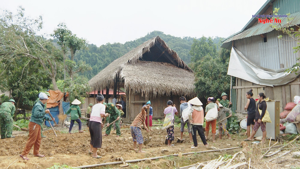Các lực lượng Bộ đội Biên phòng, Kiểm lâm và người dân tập trung tháo dỡ nhà ông Lê Văn Thành ở bản Búng, xã Môn Sơn.