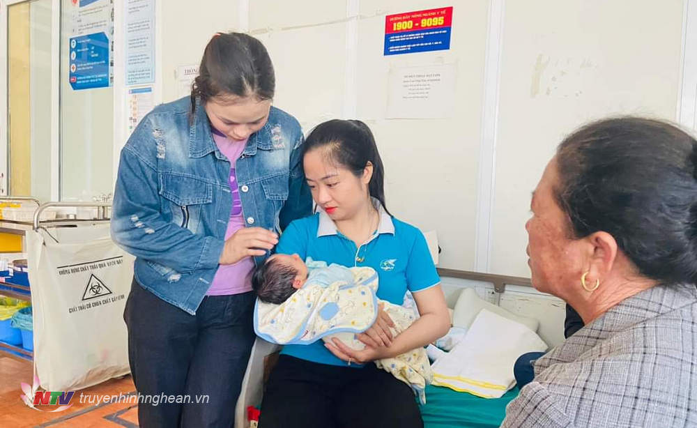 Đại diện chính quyền địa phương và Hội LHPN xã Quỳnh Lập thăm hỏi cháu bé và động viên gia đình