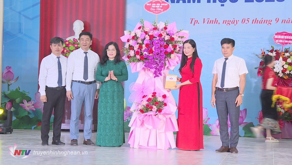 Đồng chí Nguyễn Thị Kim Chi thay mặt Tỉnh ủy - HĐND - UBND - UBMTTQ tỉnh trao tặng lẵng hoa tới nhà trường. 