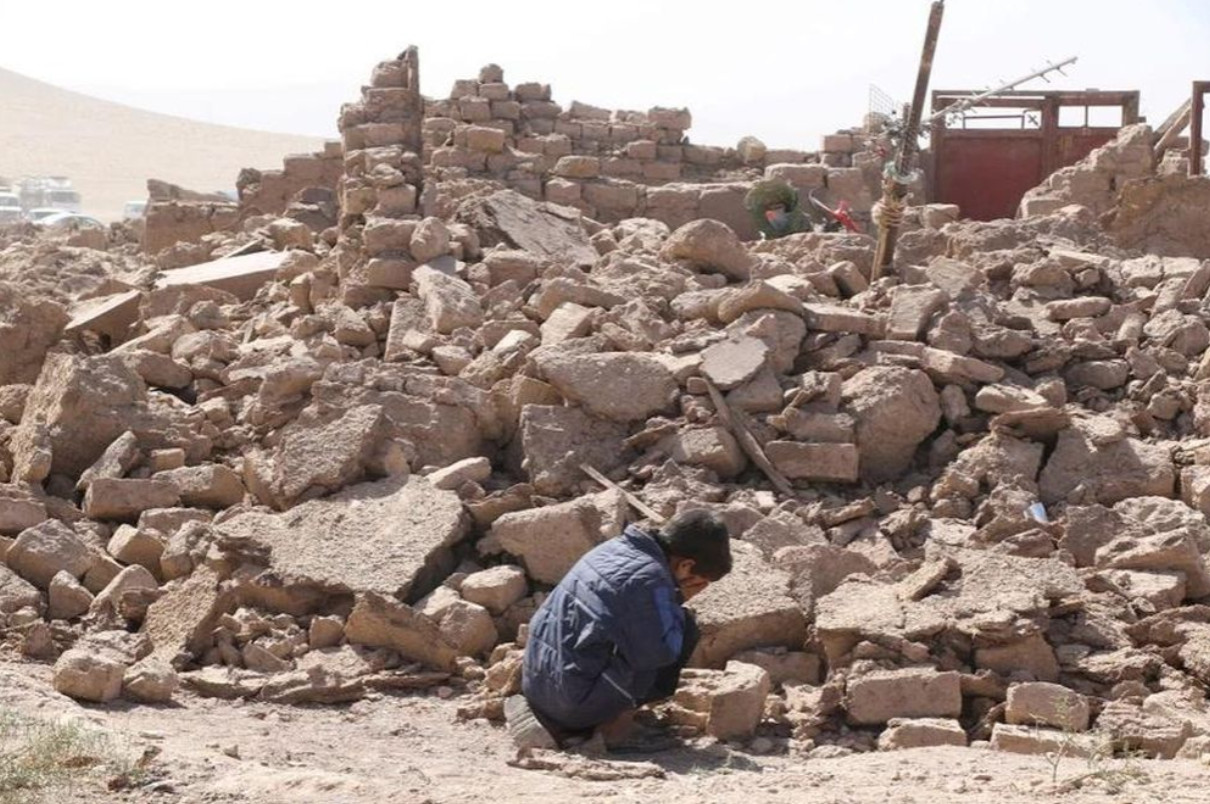 Em bé gục khóc trước đống đổ nát sau trận động đất hôm 7-10 tại tỉnh Herat (miền tây Afghanistan). Ảnh: REUTERS