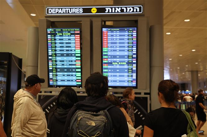 Hành khách theo dõi các chuyến bay bị hủy do xung đột Hamas - Israel trên bảng điện tử tại sân bay Ben Gurion ở Tel Aviv, Israel ngày 7/10/2023. 
