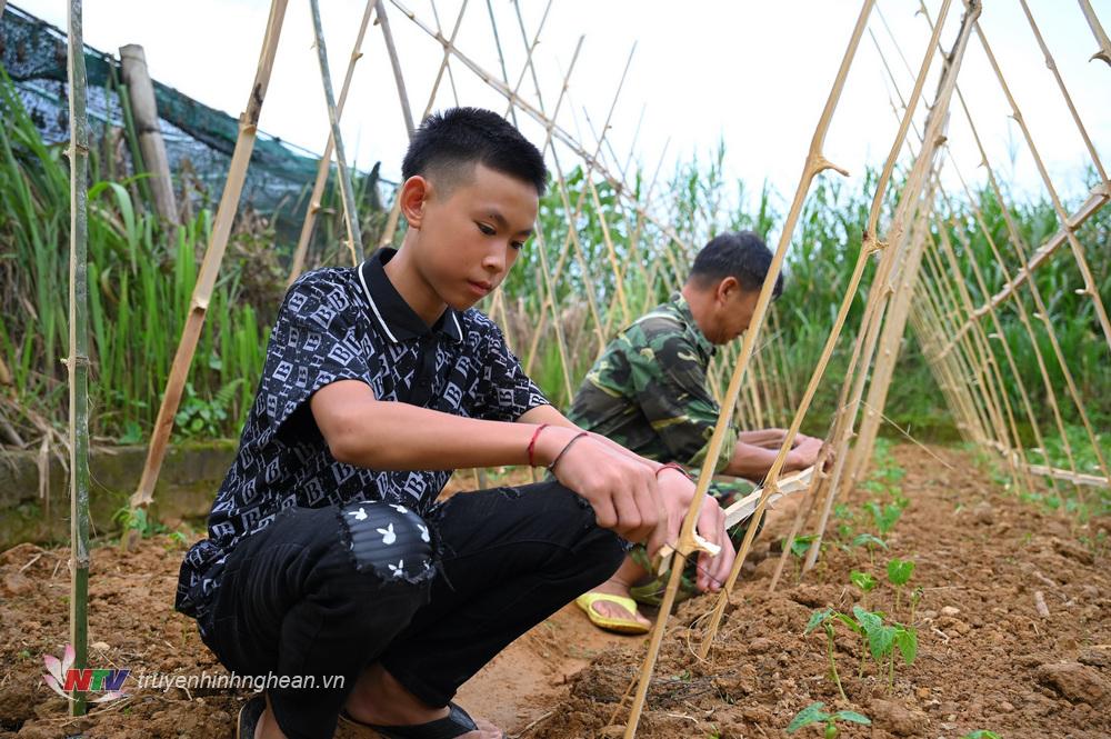 Cán bộ Đồn BP Na Ngoi hướng dẫn các con tăng gia sản xuất.