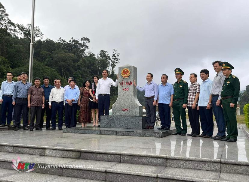 Các đại biểu chụp ảnh lưu niệm tại cột mốc