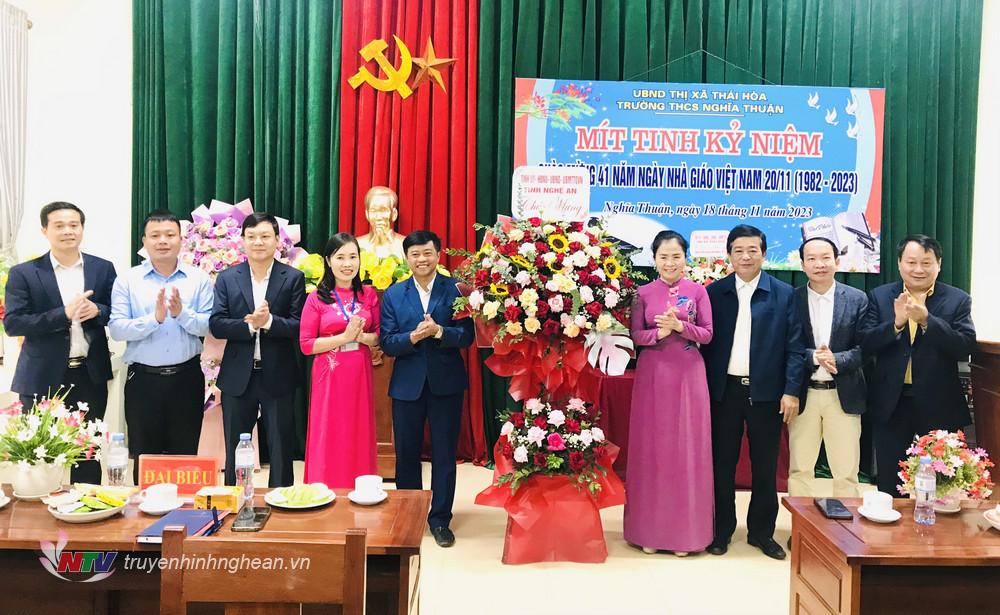 Đoàn công tác trao tặng lẵng hoa tươi thắm tới tập thể Trường THCS Nghĩa Thuận. 