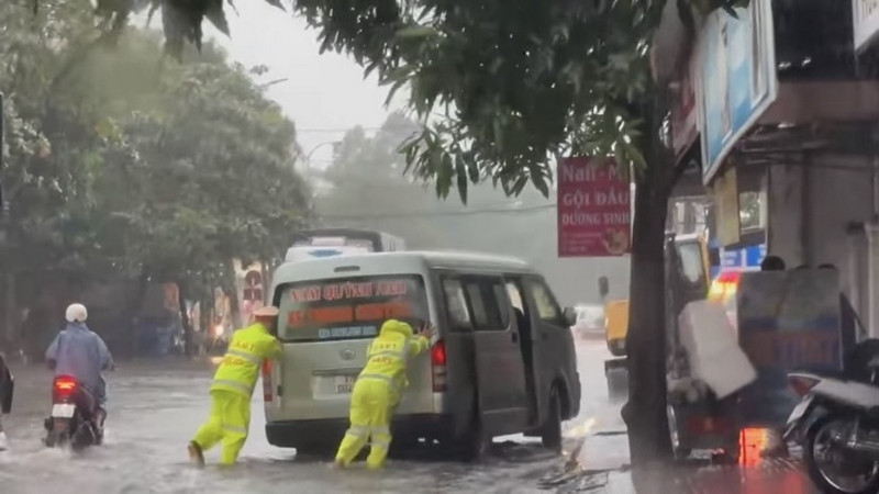 Lực lượng Cảnh sát giao thông Công an TP Vinh hỗ trợ xe gặp sự cố do đường ngập.