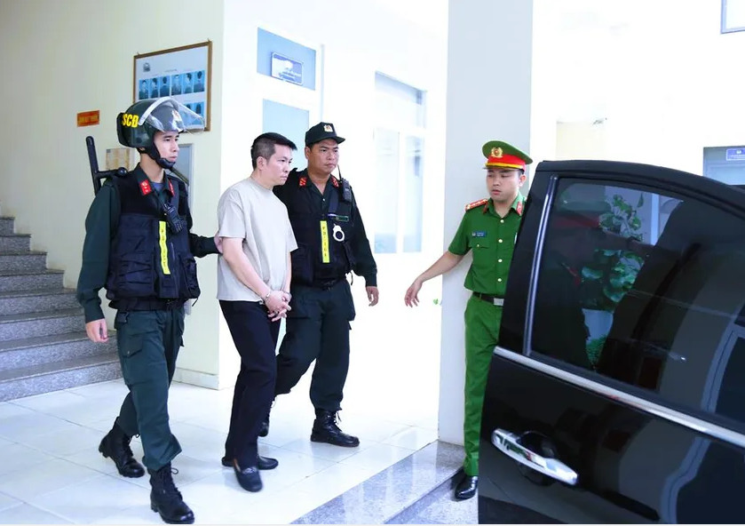 Công an áp giải Nguyễn Quốc Vũ (48 tuổi, ngụ TP.HCM, chồng ca sĩ Đoàn Di Băng). Ảnh: CAĐN