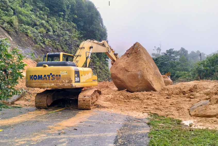 Lực lượng chức năng huy động nhân lực, máy móc xử lý sạt lở trên quốc lộ 27C. Ảnh: X.N