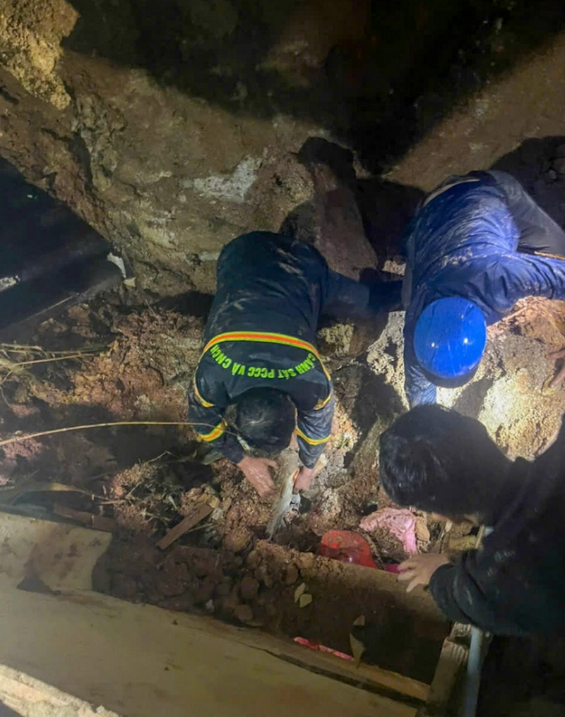 Lực lượng cứu hộ đào đất đá tiếp cận bé gái bị vùi trong vụ sạt lở - Ảnh: N.T.H.