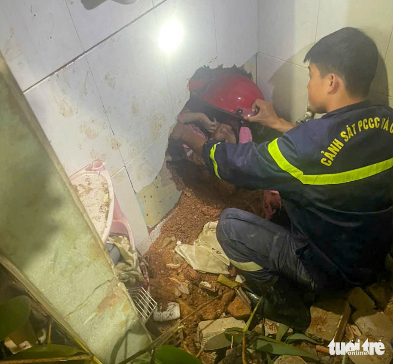 Lực lượng cứu hộ che chắn cho bé gái cẩn thận - Ảnh: N.T.H.