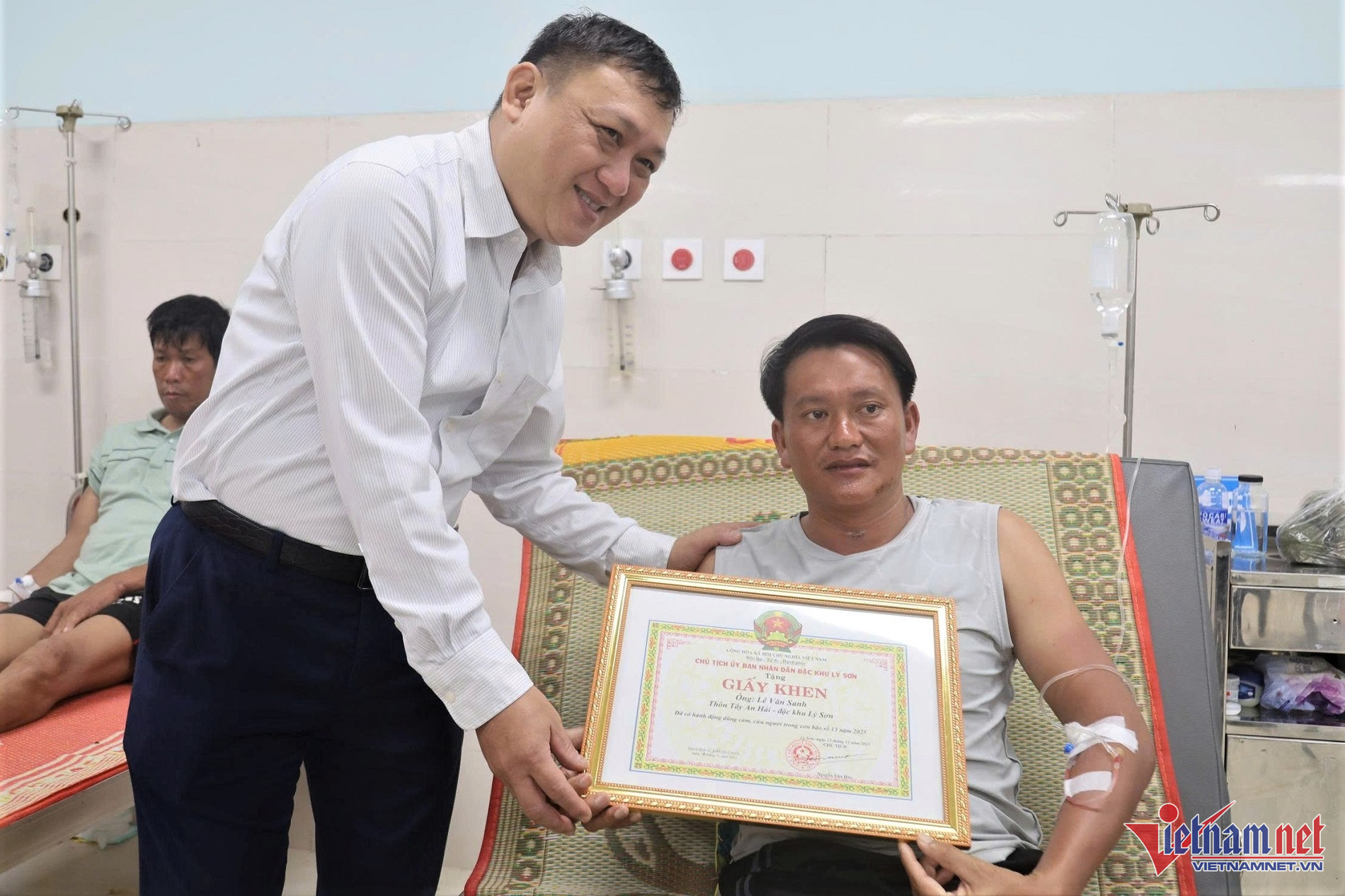 Ông Nguyễn Văn Huy, Chủ tịch UBND đặc khu Lý Sơn, trao giấy khen tặng ông Lê Văn Sanh. Ảnh: T.T