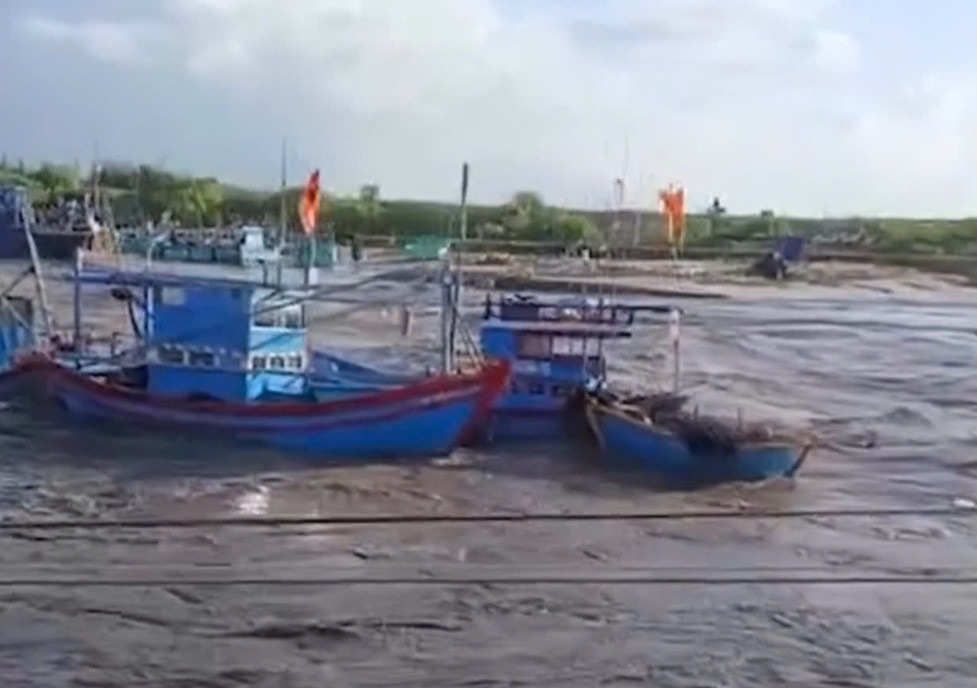 Tàu thuyền đang neo đậu tại khu vực cửa biển xã Liên Hương bị nước lũ cuốn trôi, sáng 4/12. Ảnh: NDCC