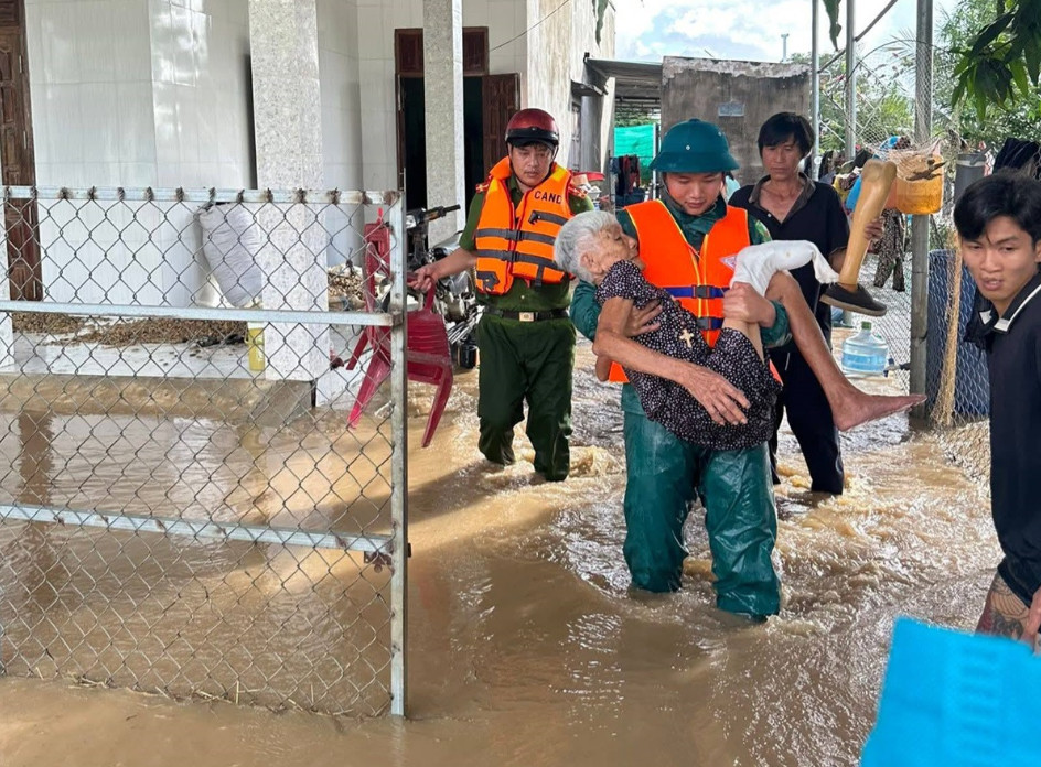 Lực lượng chức năng xã Sông Lũy hỗ trợ đưa người dân ở khu vực ngập đến vị trí an toàn. Ảnh: NDCC