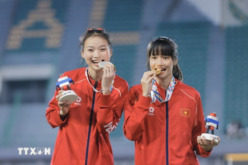 Trần Thị Loan (phải) giành HCV nội dung nhảy xa nữ cùng Hà Thị Thuý Hằng giành HCB trên bục nhận huy chương. (Ảnh: Minh Quyết/TTXVN)